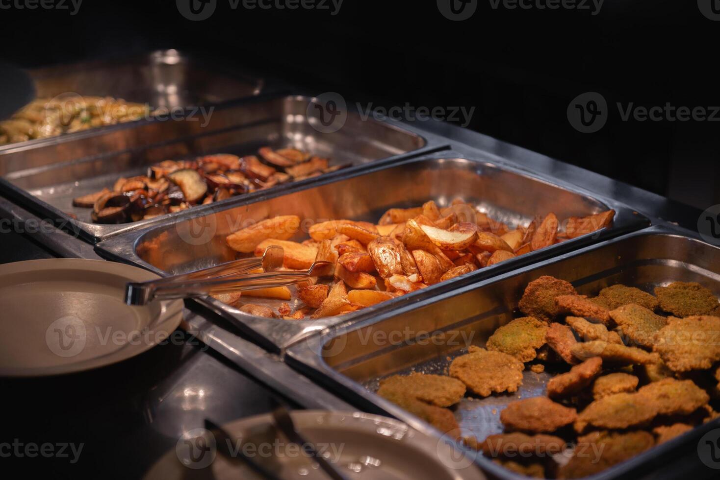 A buffet with food in metal trays photo