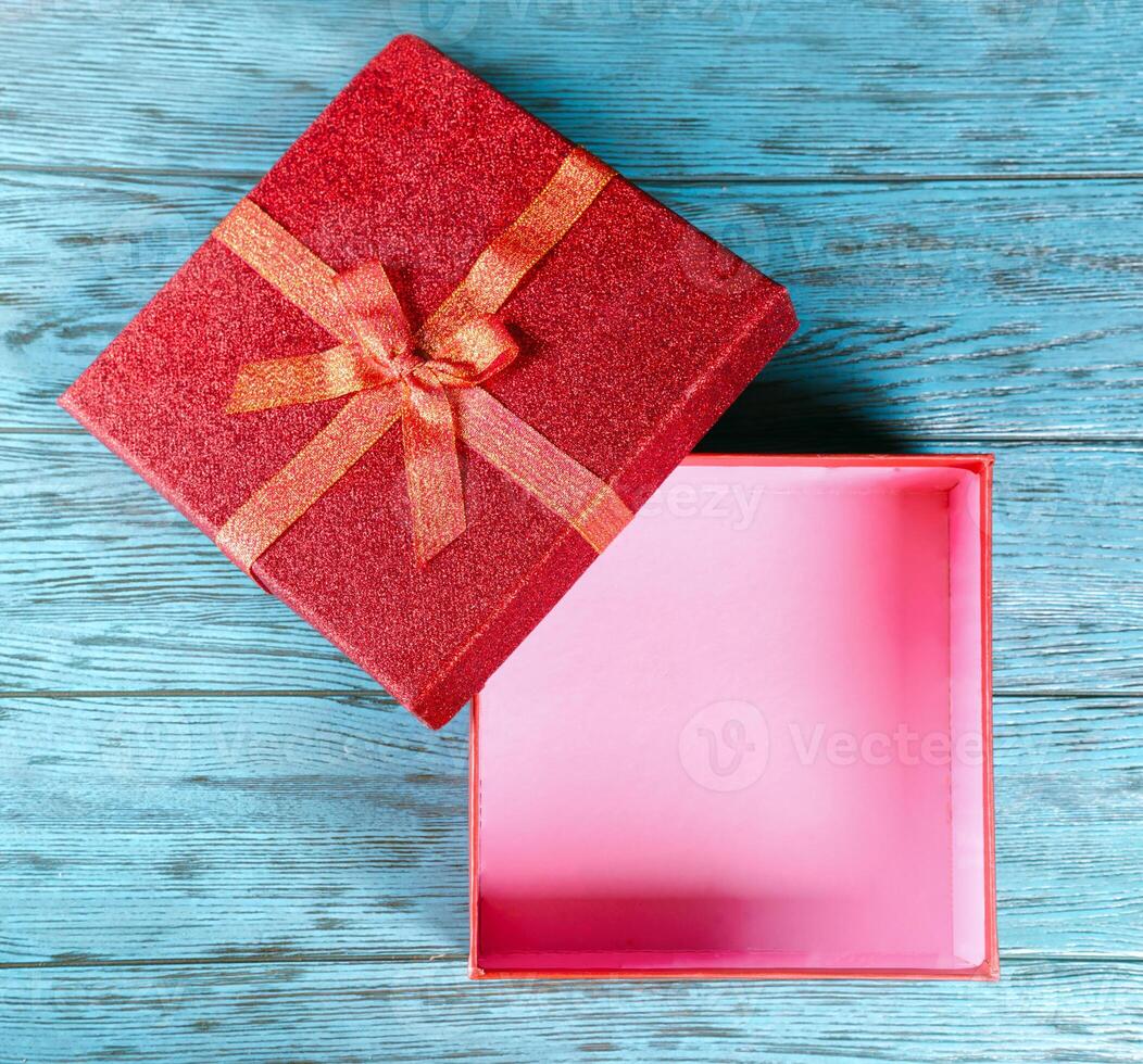 Open gift box on blue wooden background photo