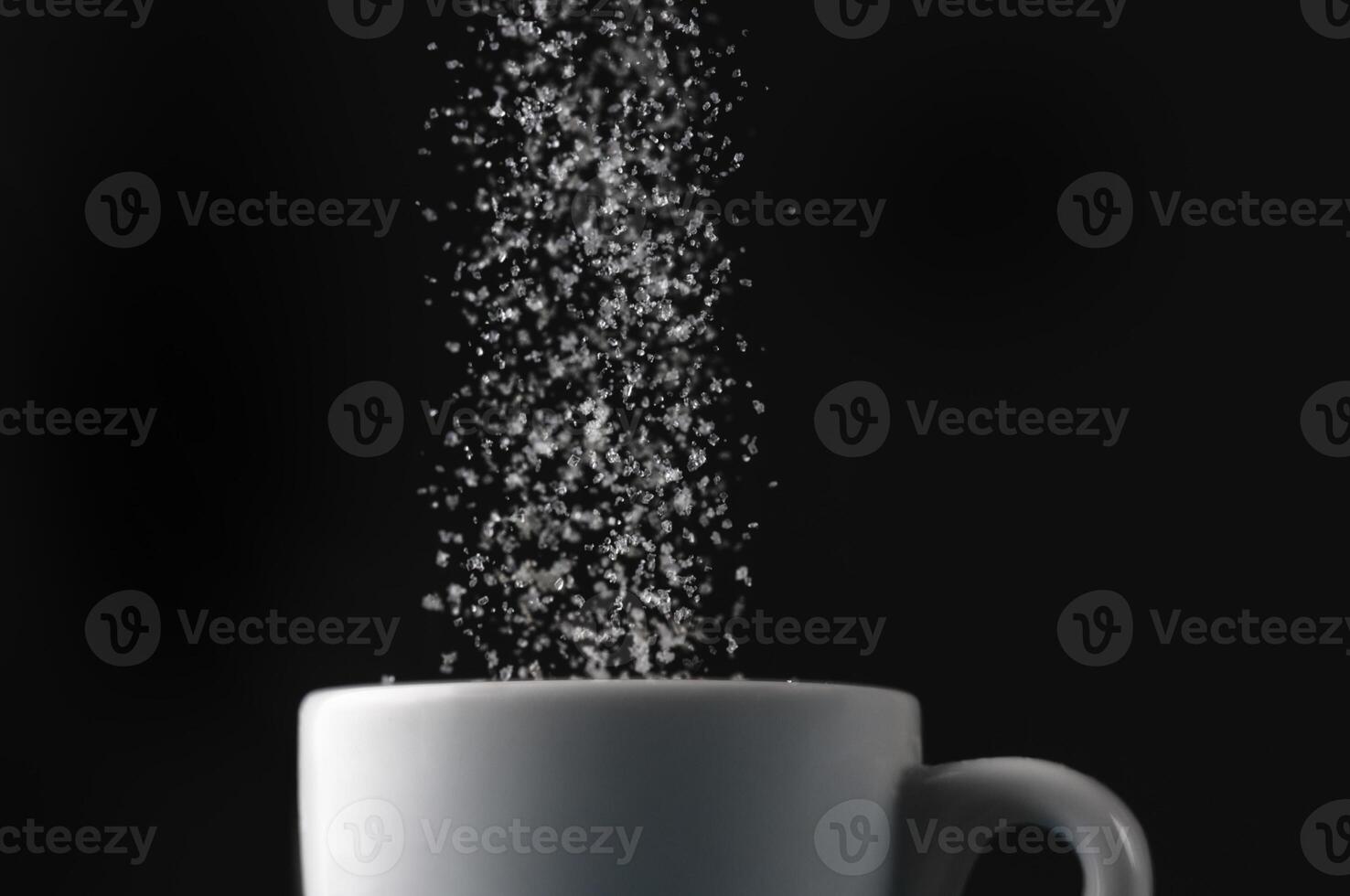 Pouring sugar into a cup photo