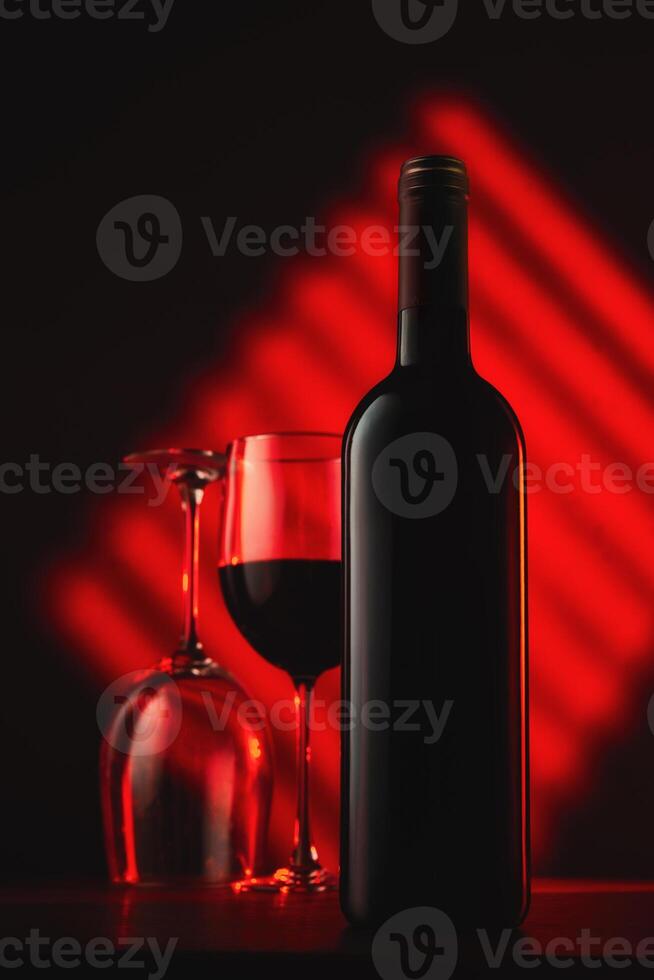 Wine bottle and glasses on red abstract background photo