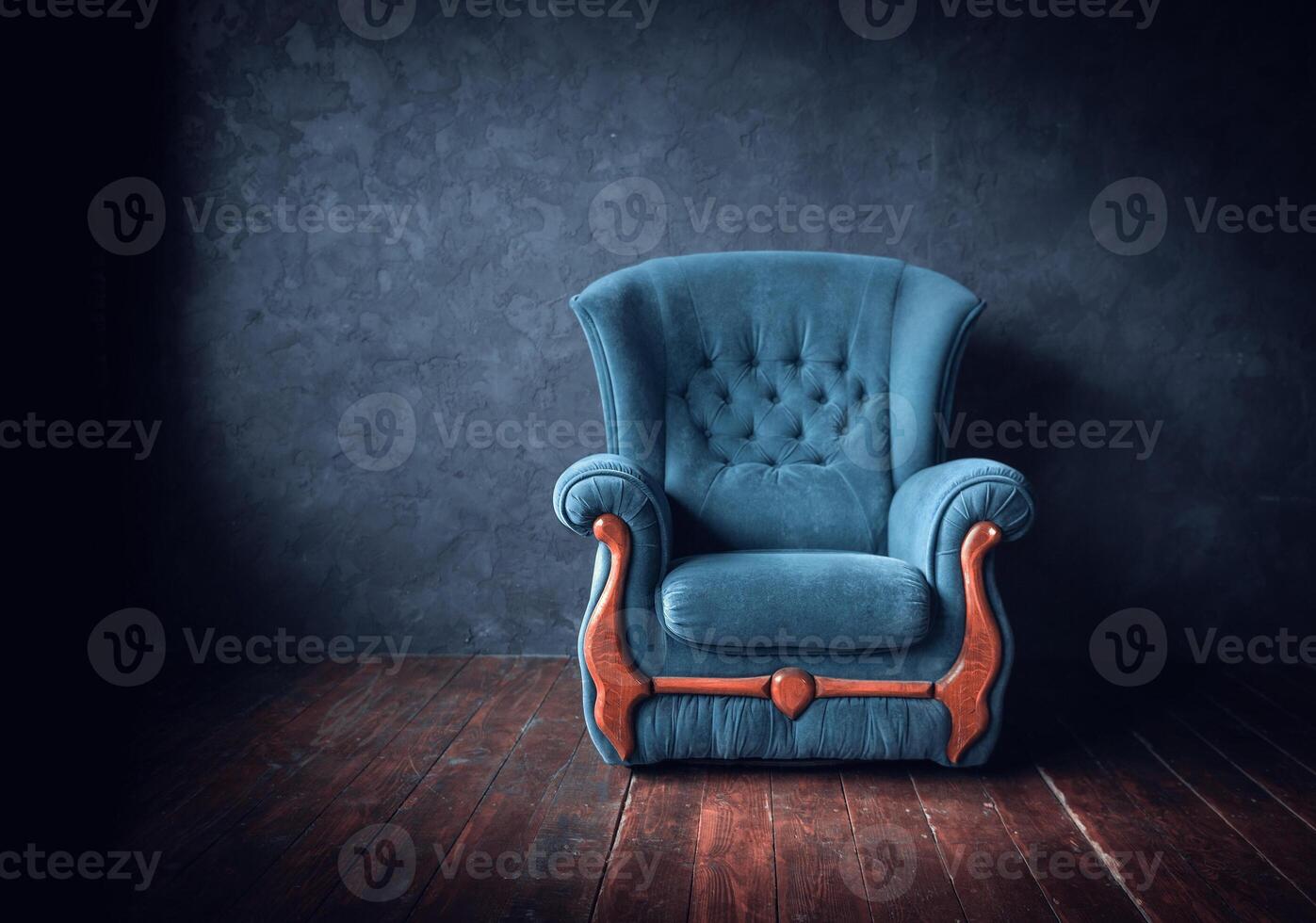 Blue chair in empty room with dark wall photo