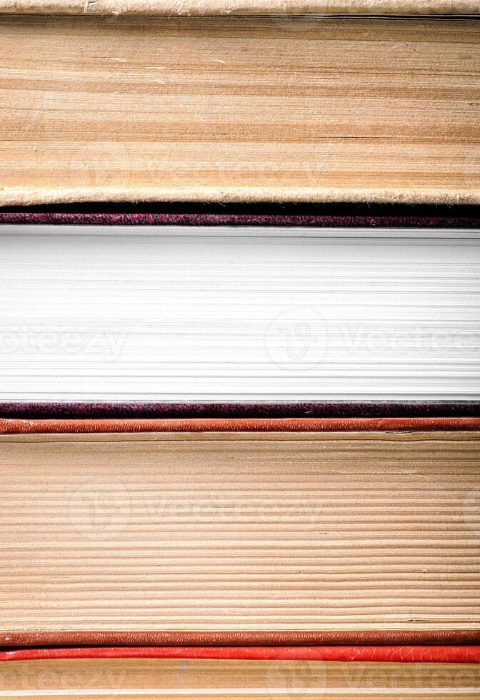 A stack of books with a white book in the middle photo