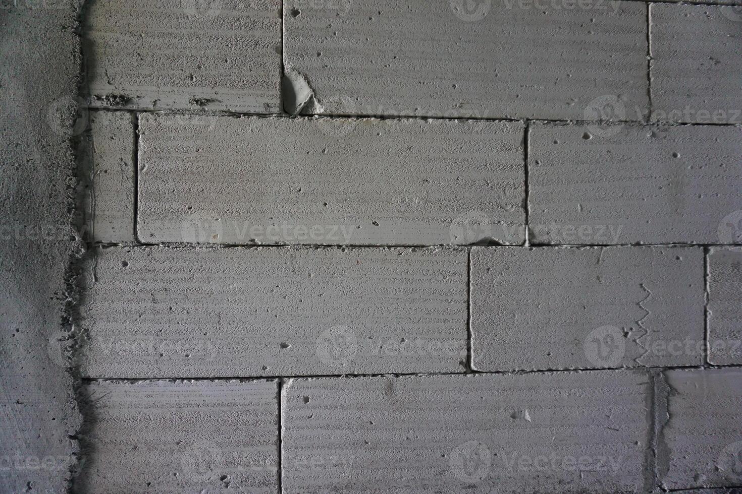 Grey concrete block wall texture indoors, construction site background photo