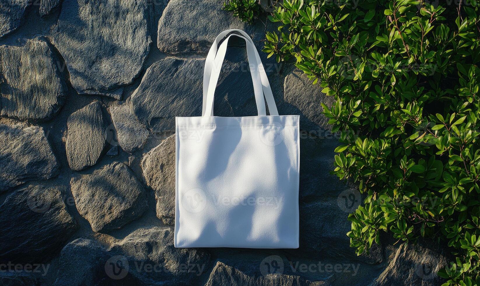 A white canvas bag is sitting on a stone wall photo