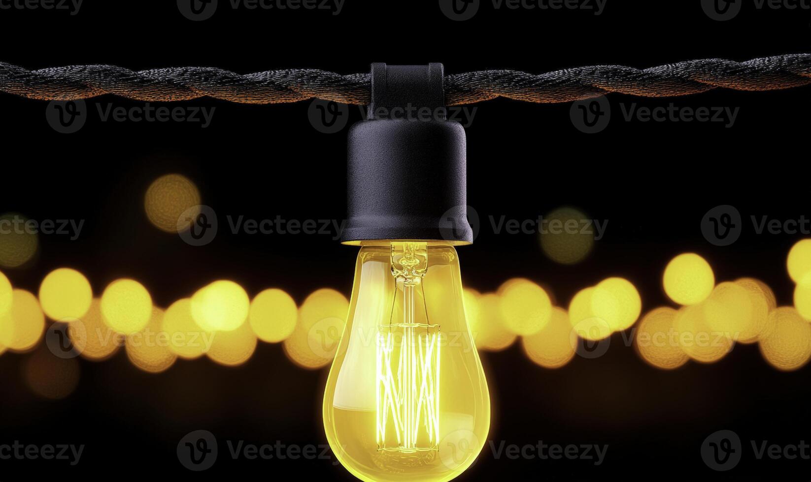 Vintage yellow light bulb hanging against a dark background with bokeh effect creating a warm and inviting ambiance for decoration or photography projects photo