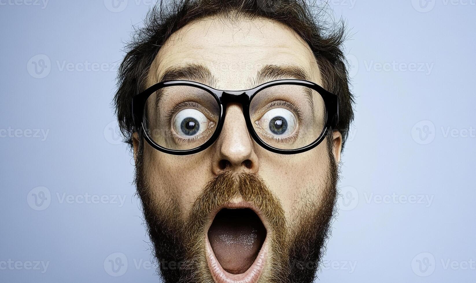 A man with glasses and a beard is making a surprised face photo