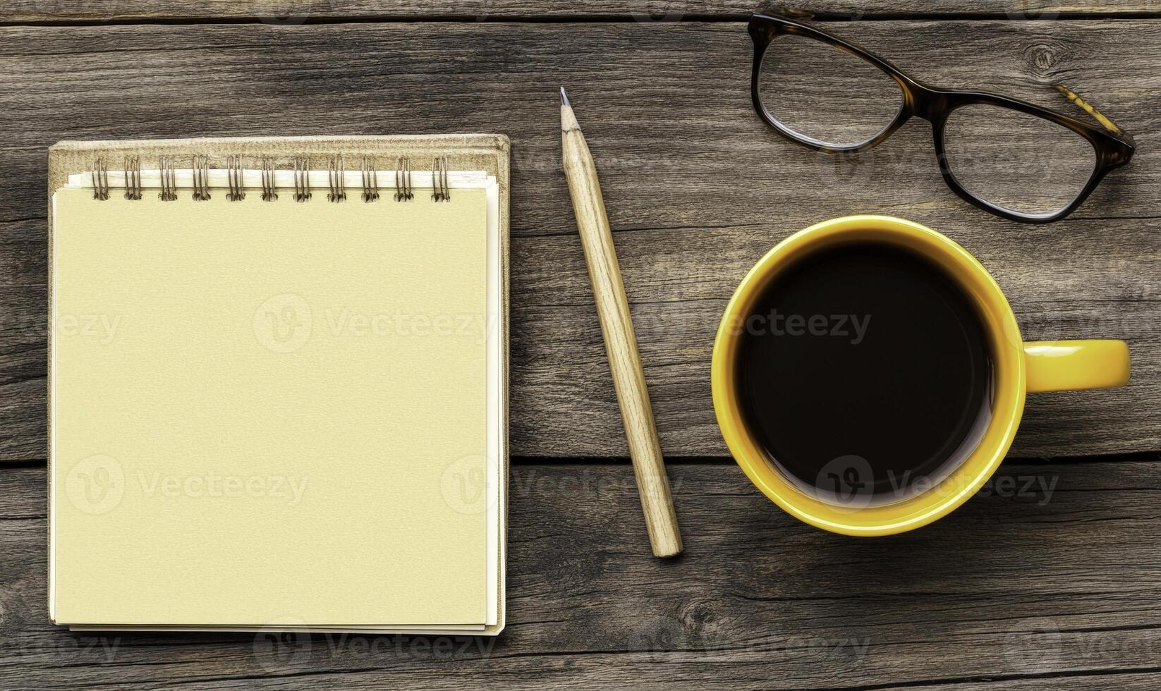 A notepad, pen, and coffee cup on a wooden table photo
