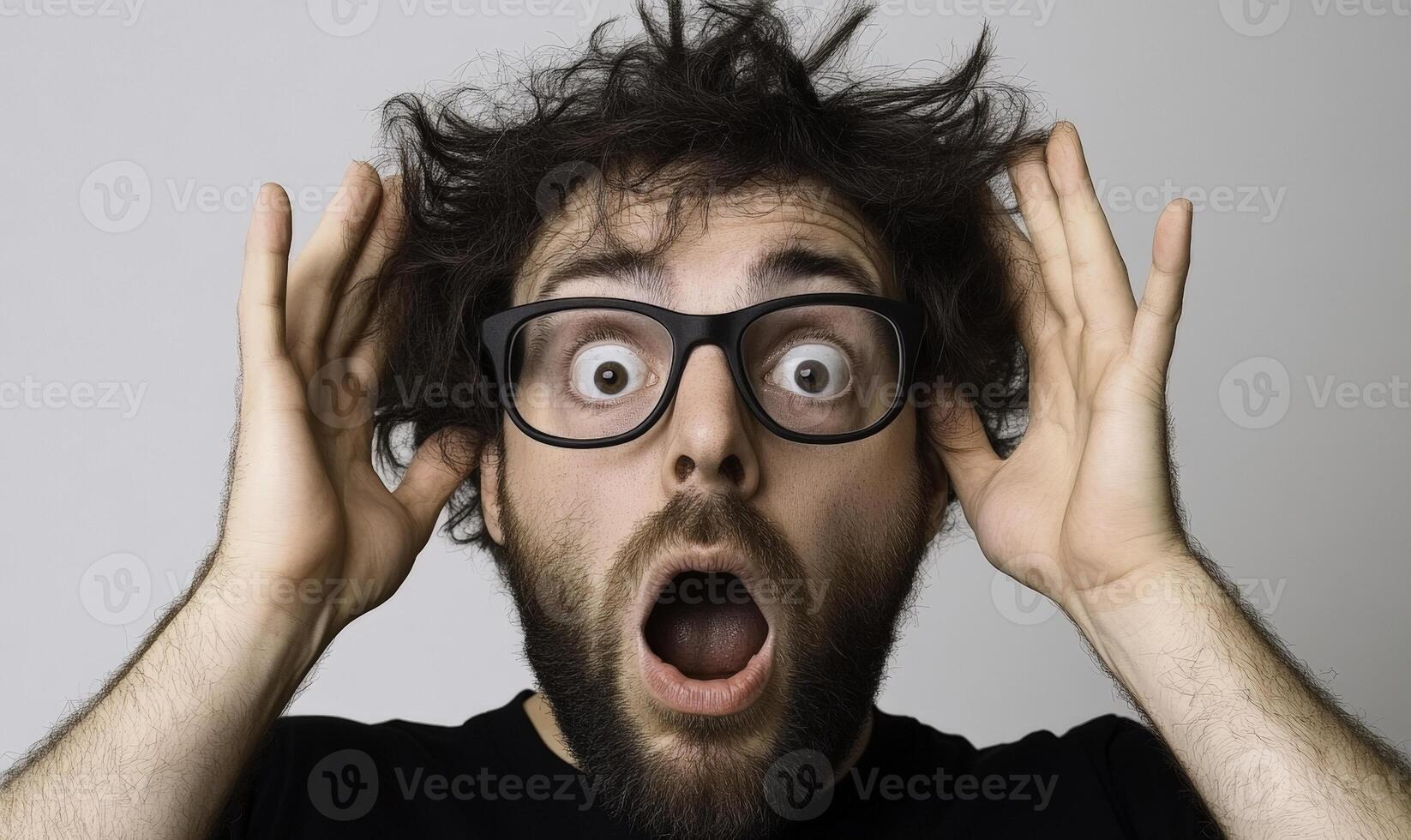 A man with glasses on his face and a shocked expression photo