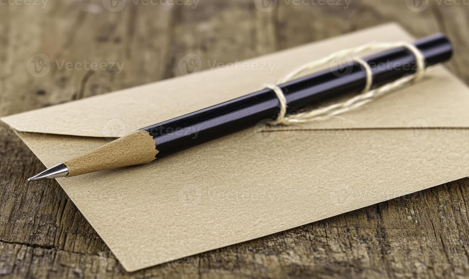 A pencil and envelope on a wooden table photo