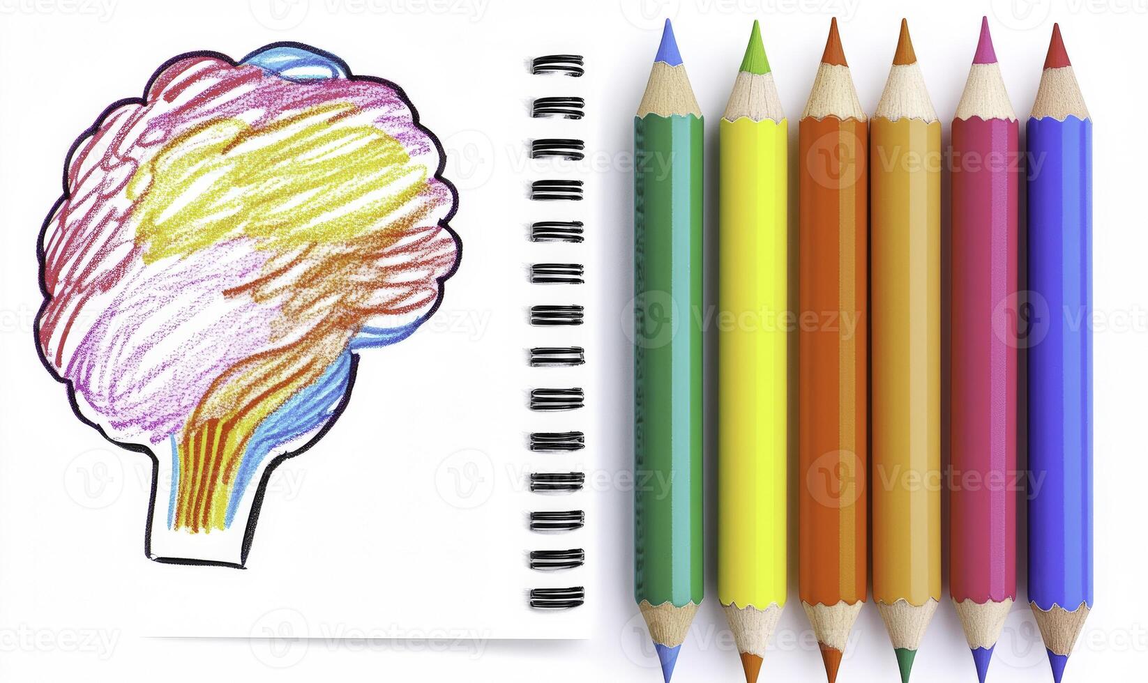 A notebook with colored pencils and a drawing of a brain photo