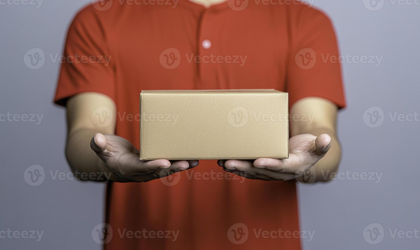 A man holding a cardboard box with a red shirt photo