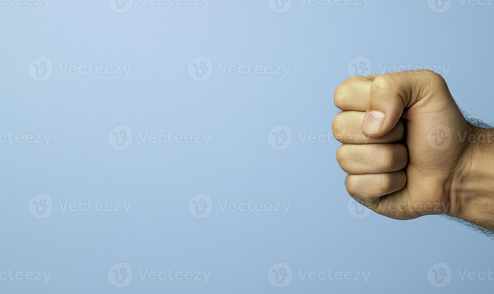 A fist is shown in the foreground of a blue background photo