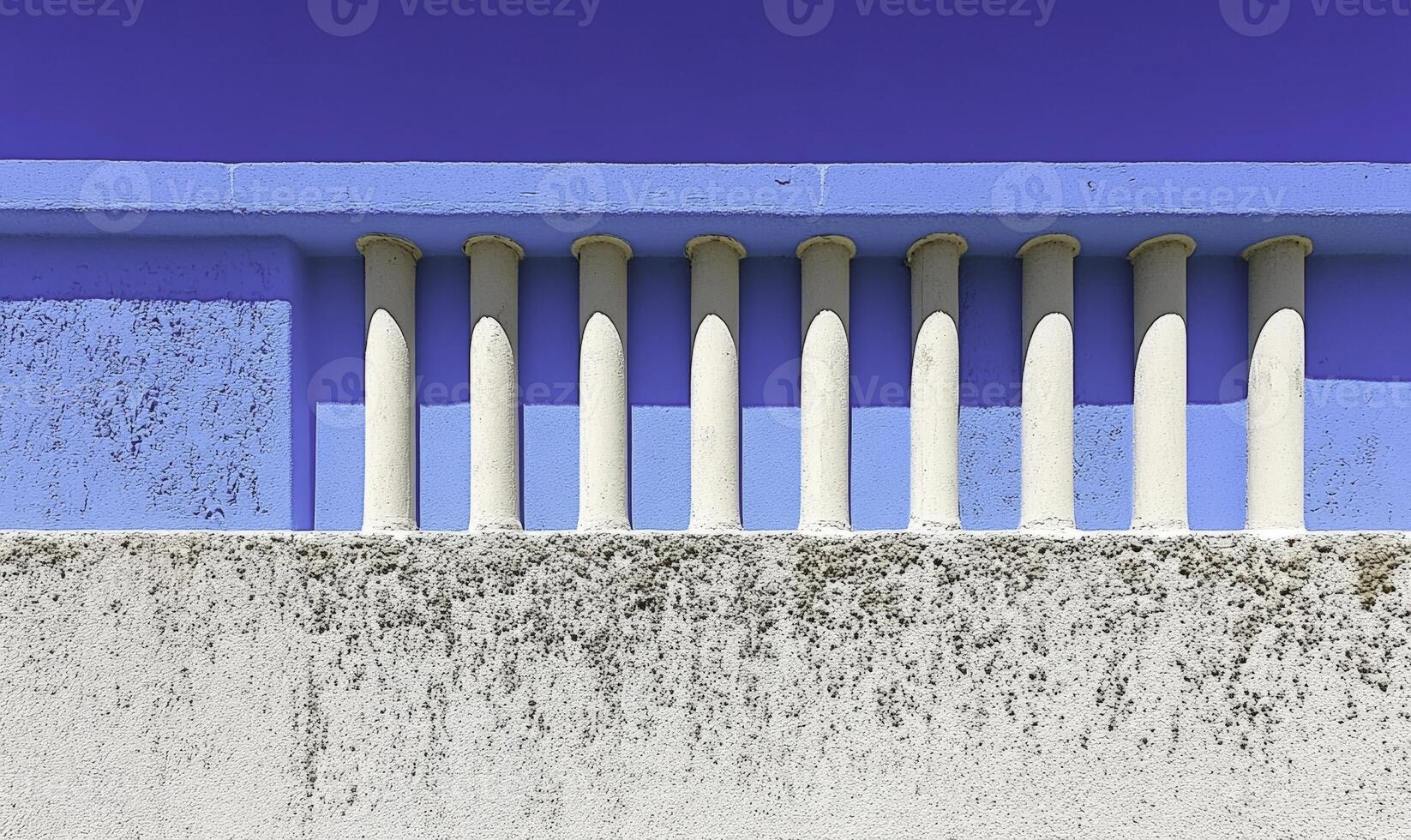 Abstract architectural design featuring elegant white columns against a vibrant blue wall under a clear blue sky showcasing minimalist beauty and simplicity photo