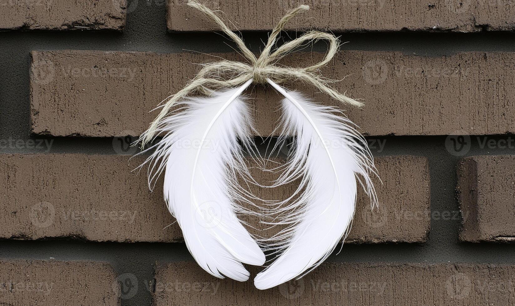 White feather decoration hanging on a rustic brick wall with a jute twine bow creating a charming and cozy atmosphere for home decor photo