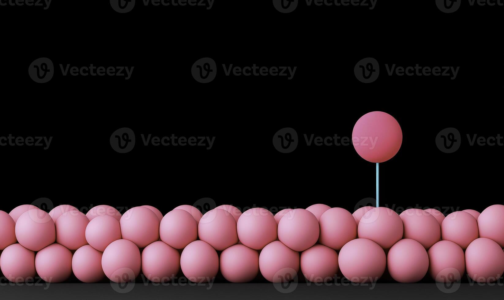 Pink spheres arranged in a row with a single distinguishable sphere on a stick showcasing uniqueness against a black background photo