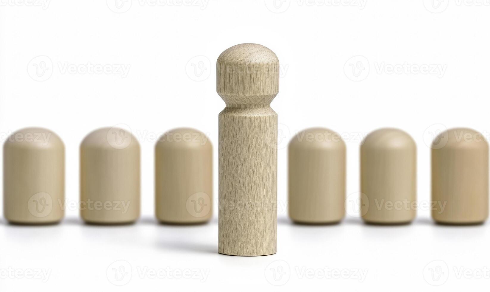 Wooden figurines arranged in a line with one figure standing out in focus, symbolizing uniqueness and individuality in a minimalist setting photo