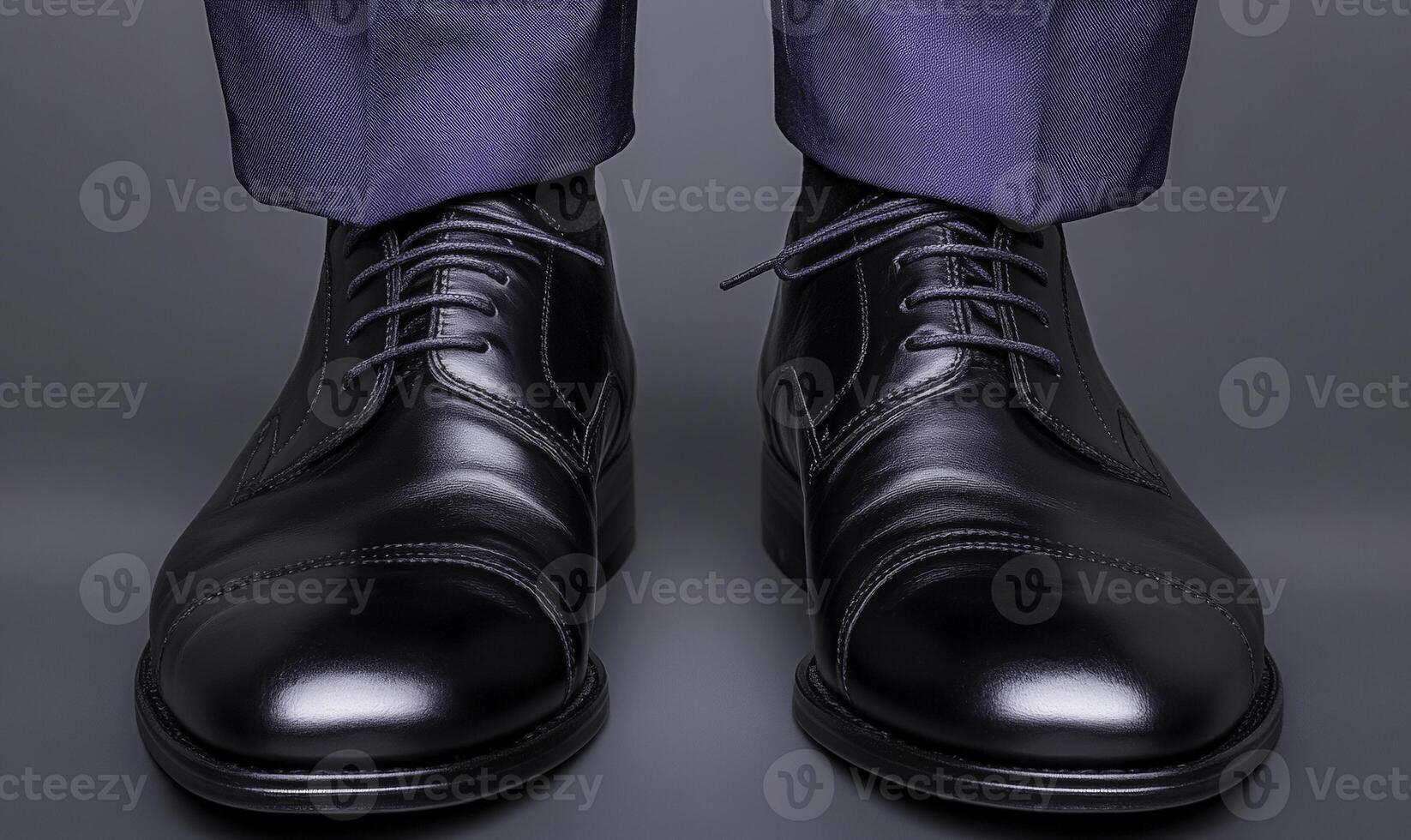 Polished Black Dress Shoes with Classic Lace Design Worn by Businessman Standing in Formal Outfit Against Gray Background photo