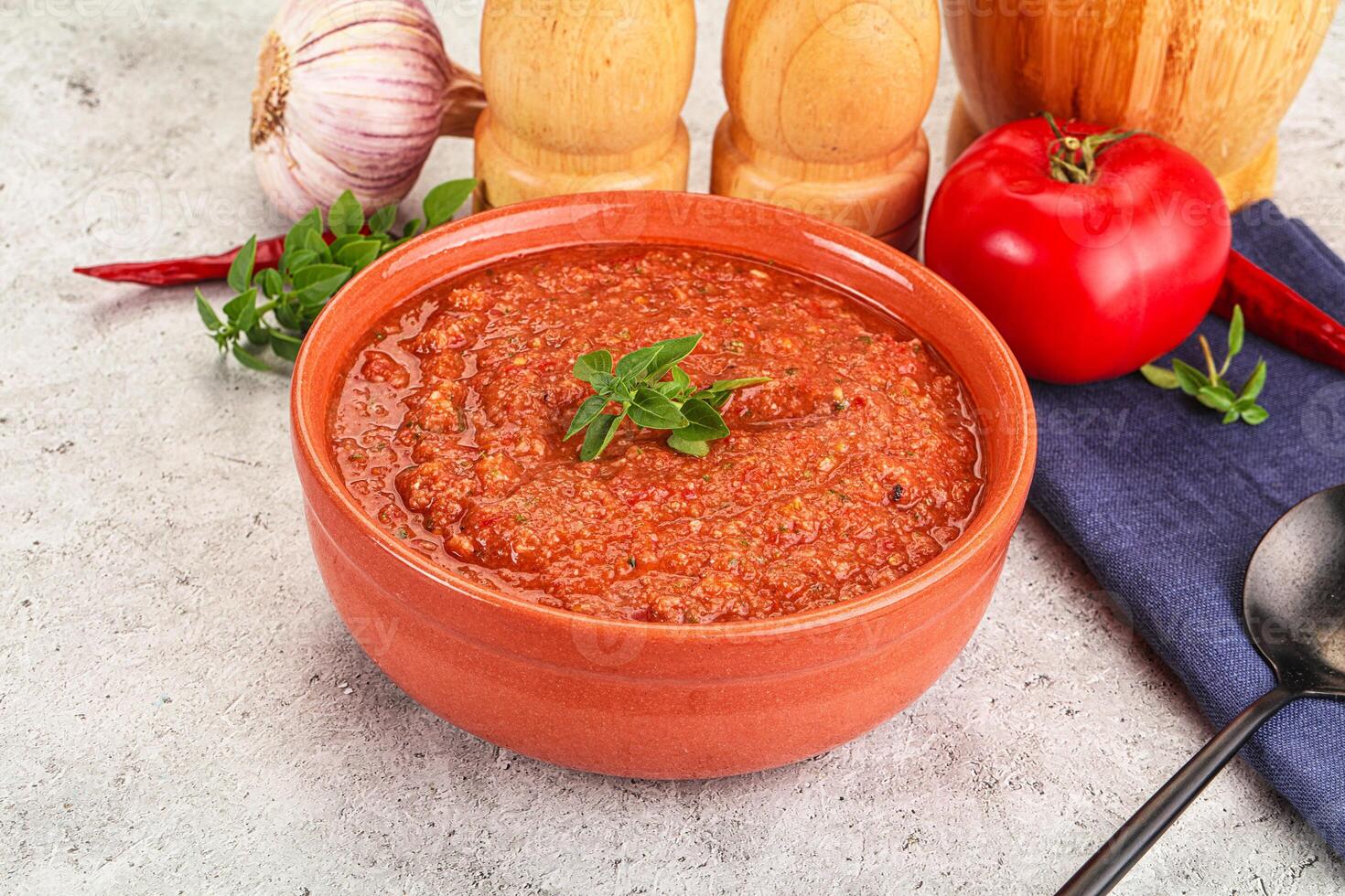 A bowl of chili with a spoon and a knife photo