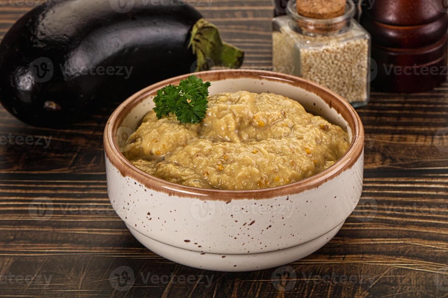 A bowl of food sitting on a table next to an eggplant photo