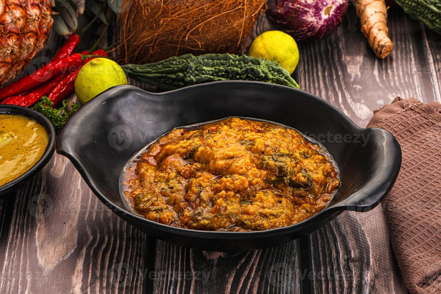 A bowl of food with a spoon and a coconut photo