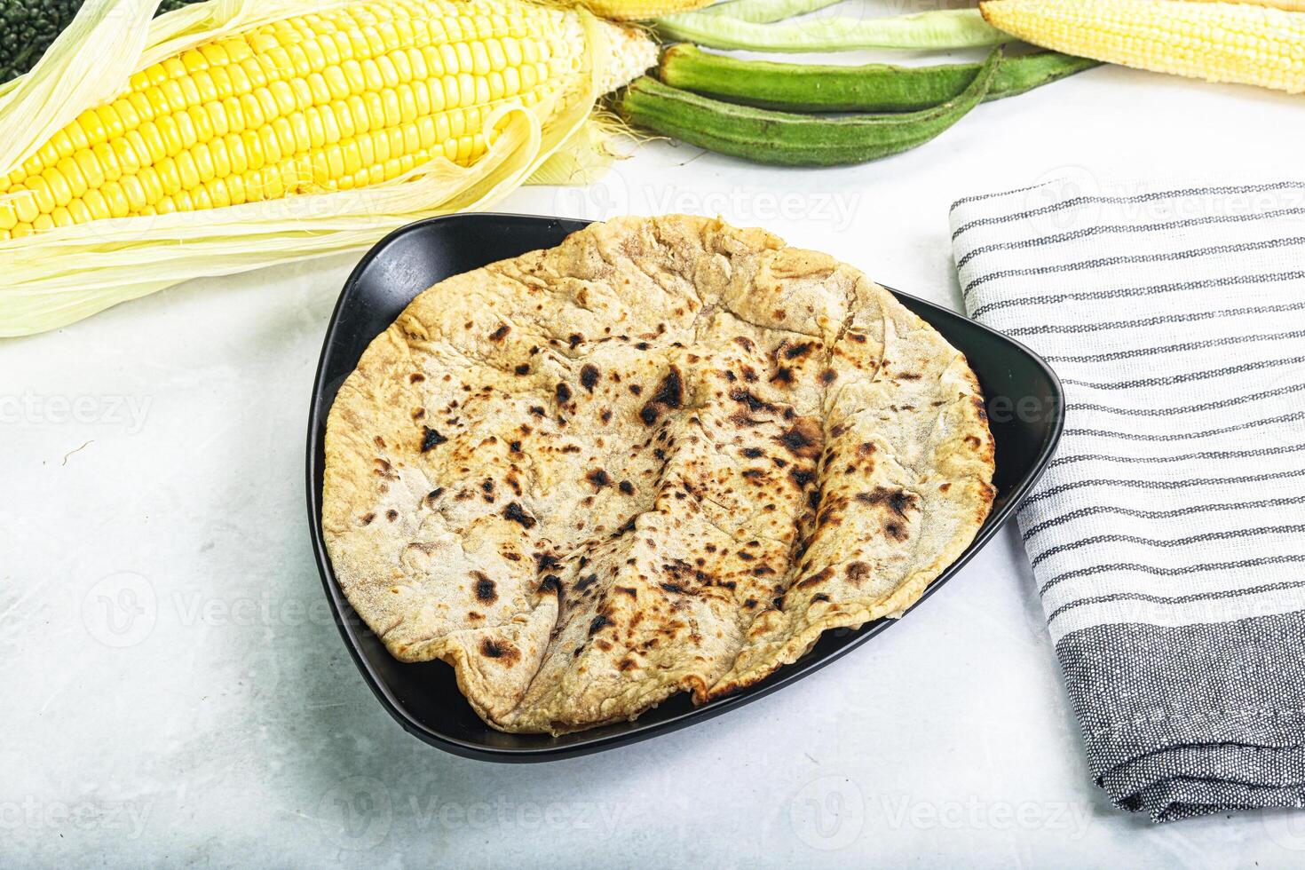 A plate with corn, corn on the cob, and a tortilla photo