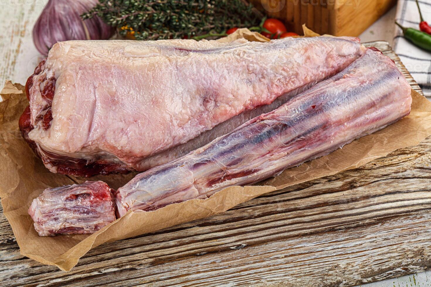 Raw meat on a wooden table with vegetables photo