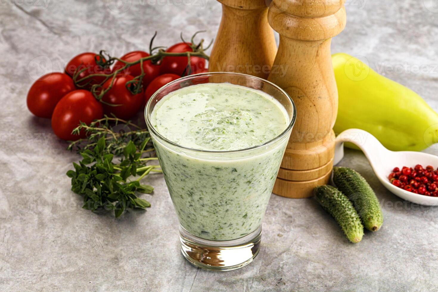 A glass of green smoothie with tomatoes, peppers and other ingredients photo