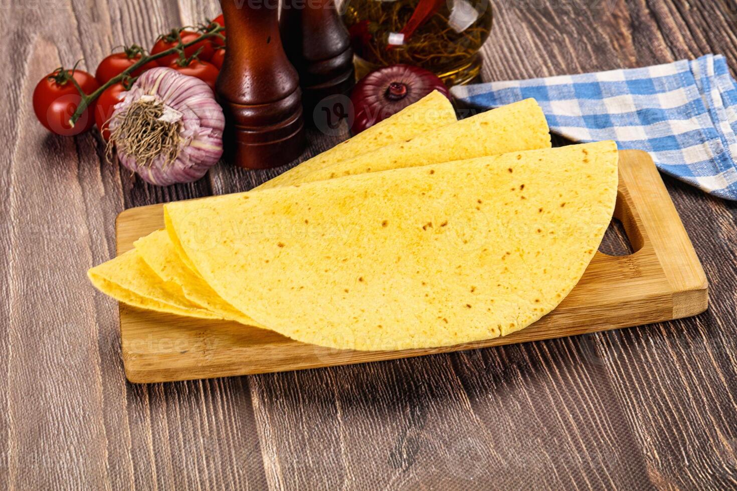 A tortilla on a cutting board with a knife and other ingredients photo