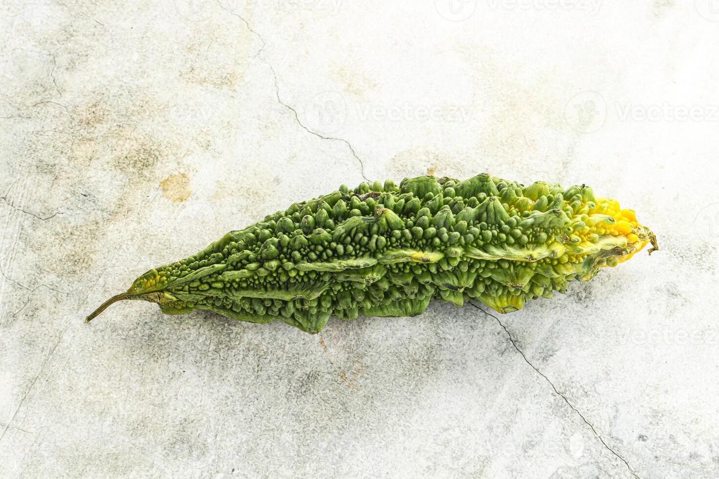 A green vegetable with a yellow stem on a white surface photo