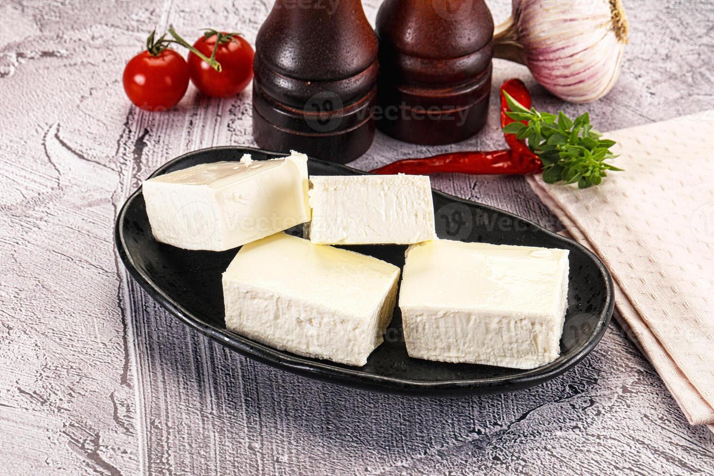 A plate of cheese and other ingredients on a table photo