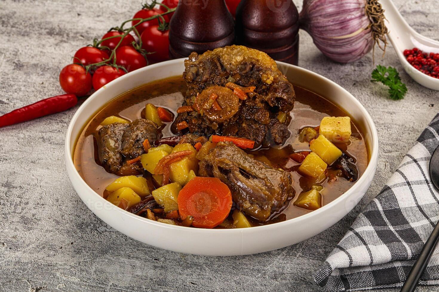 A bowl of stew with meat, potatoes and vegetables photo