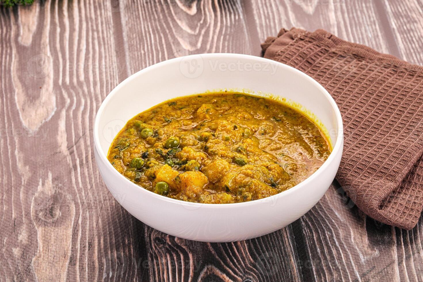 A bowl of soup with a spoon on a wooden table photo
