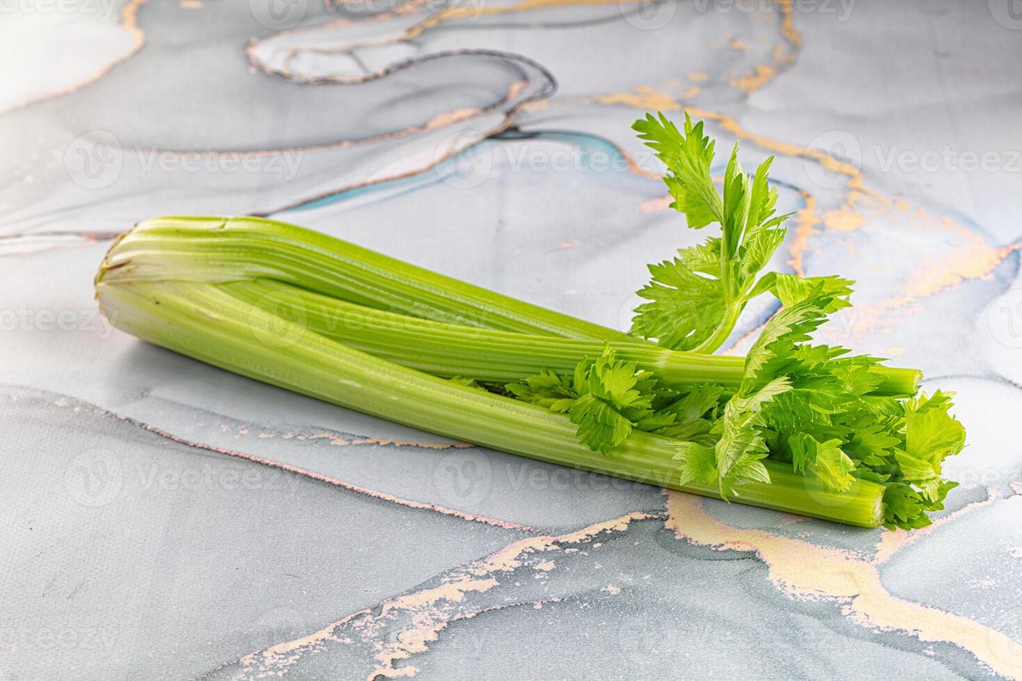 A celery stalk on a marble surface photo