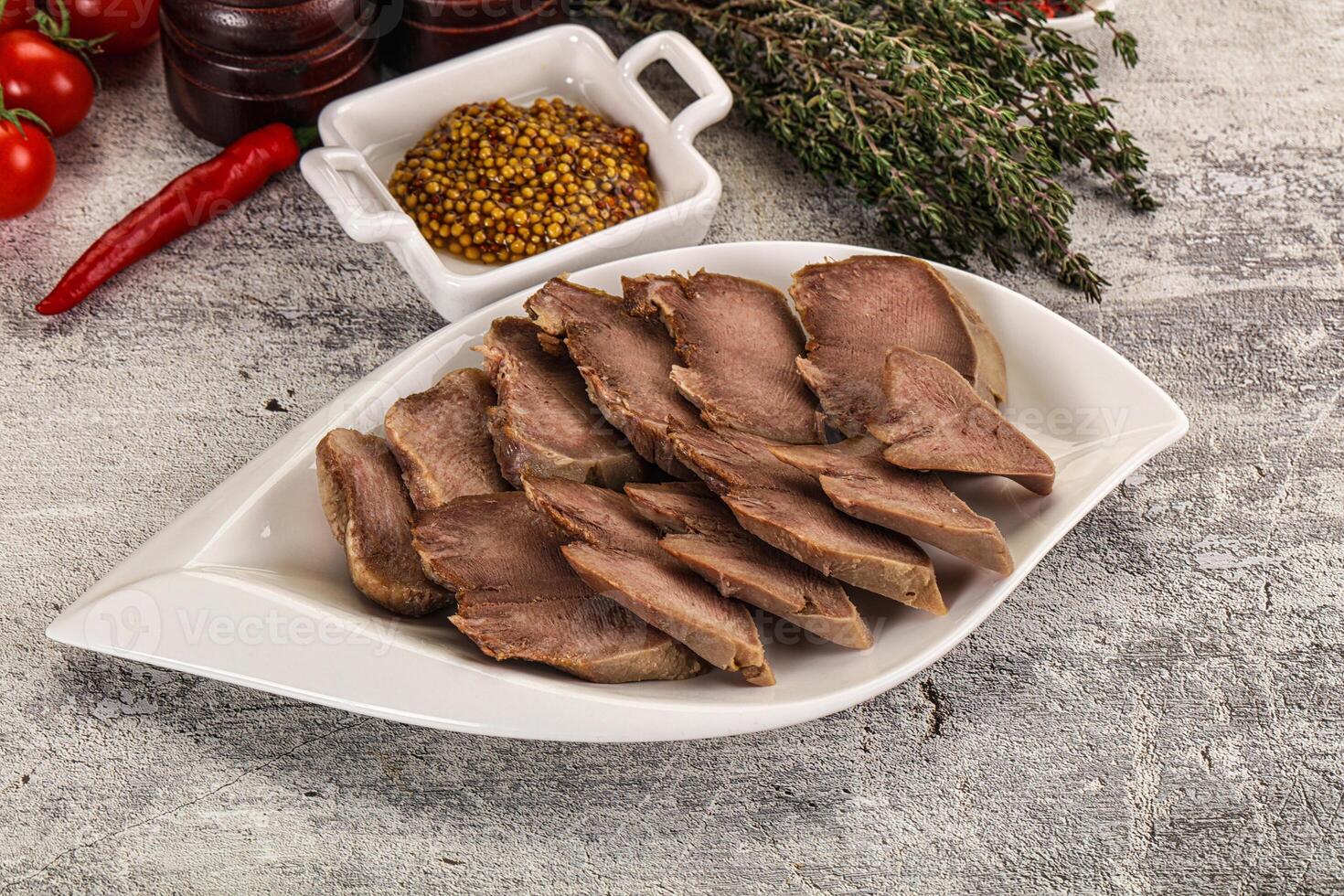 A plate of meat with spices and herbs on a table photo