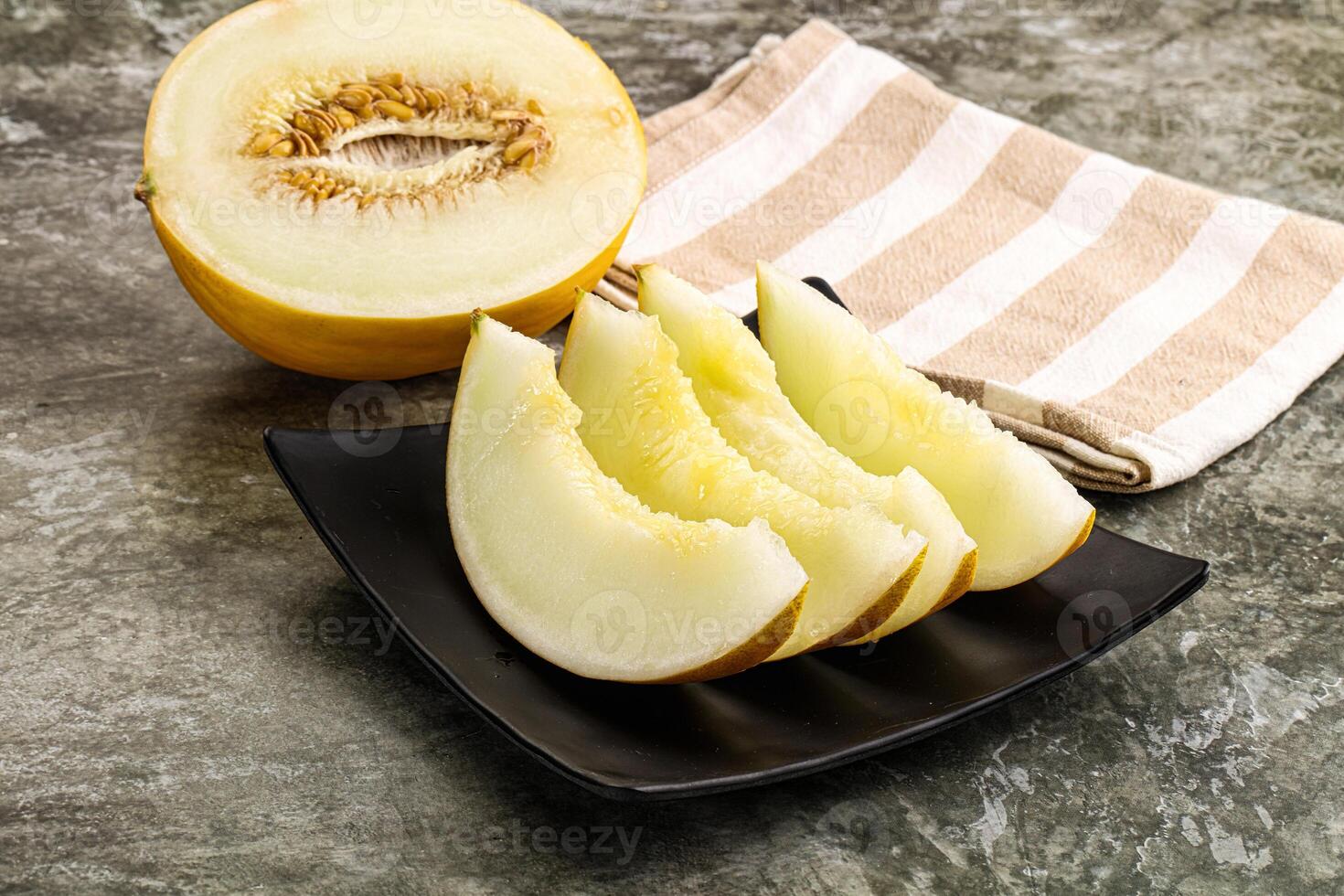 A melon slice on a plate with a towel photo