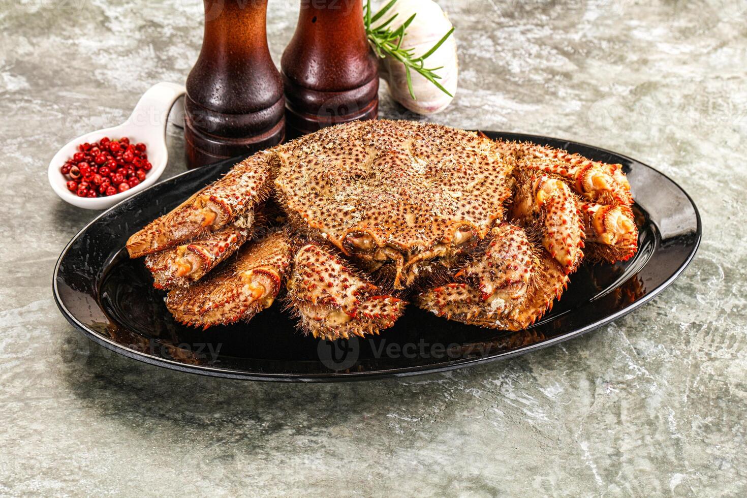 A large crab on a plate with spices and condiments photo