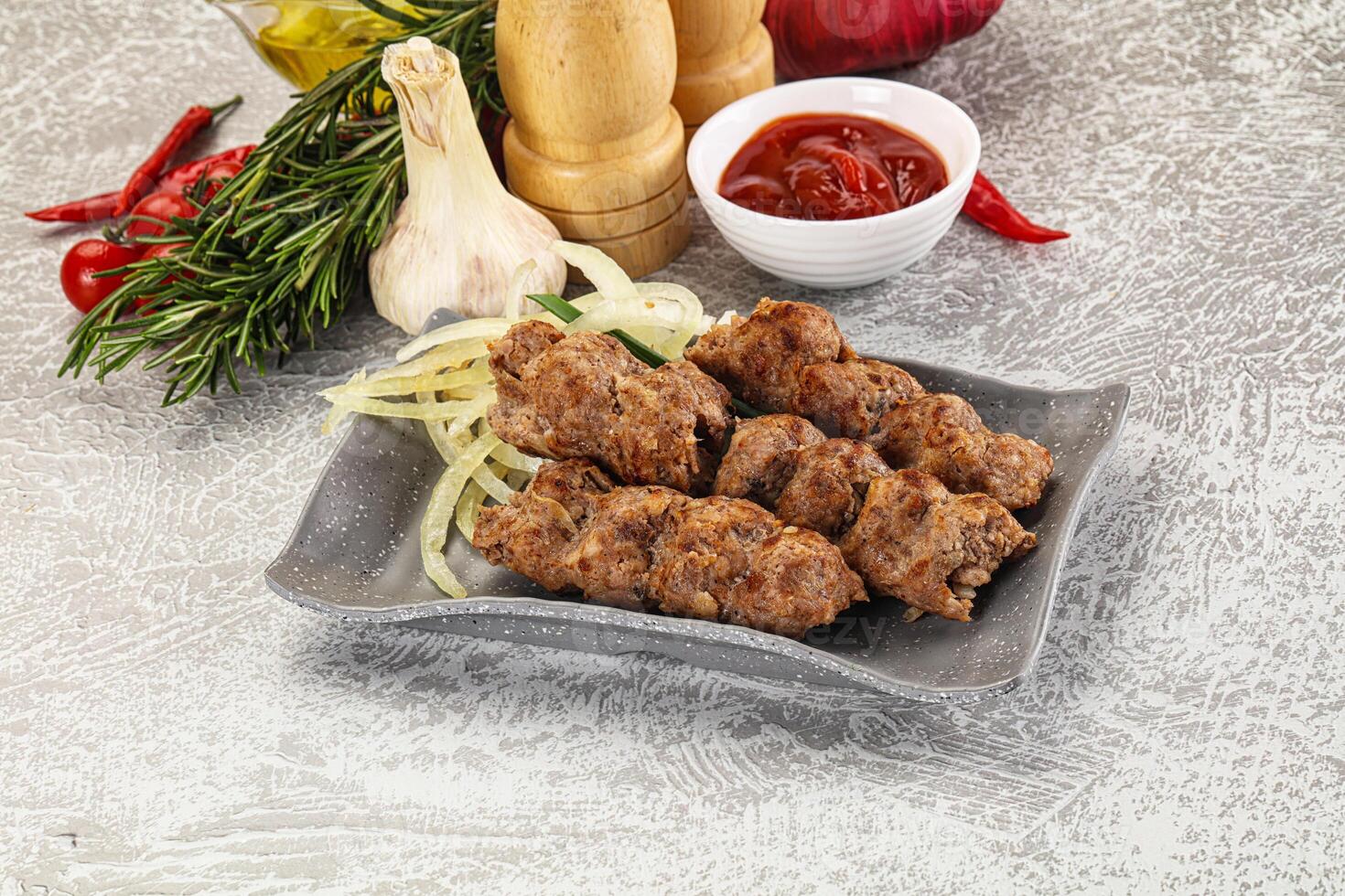 A plate with meat skewers and other ingredients photo