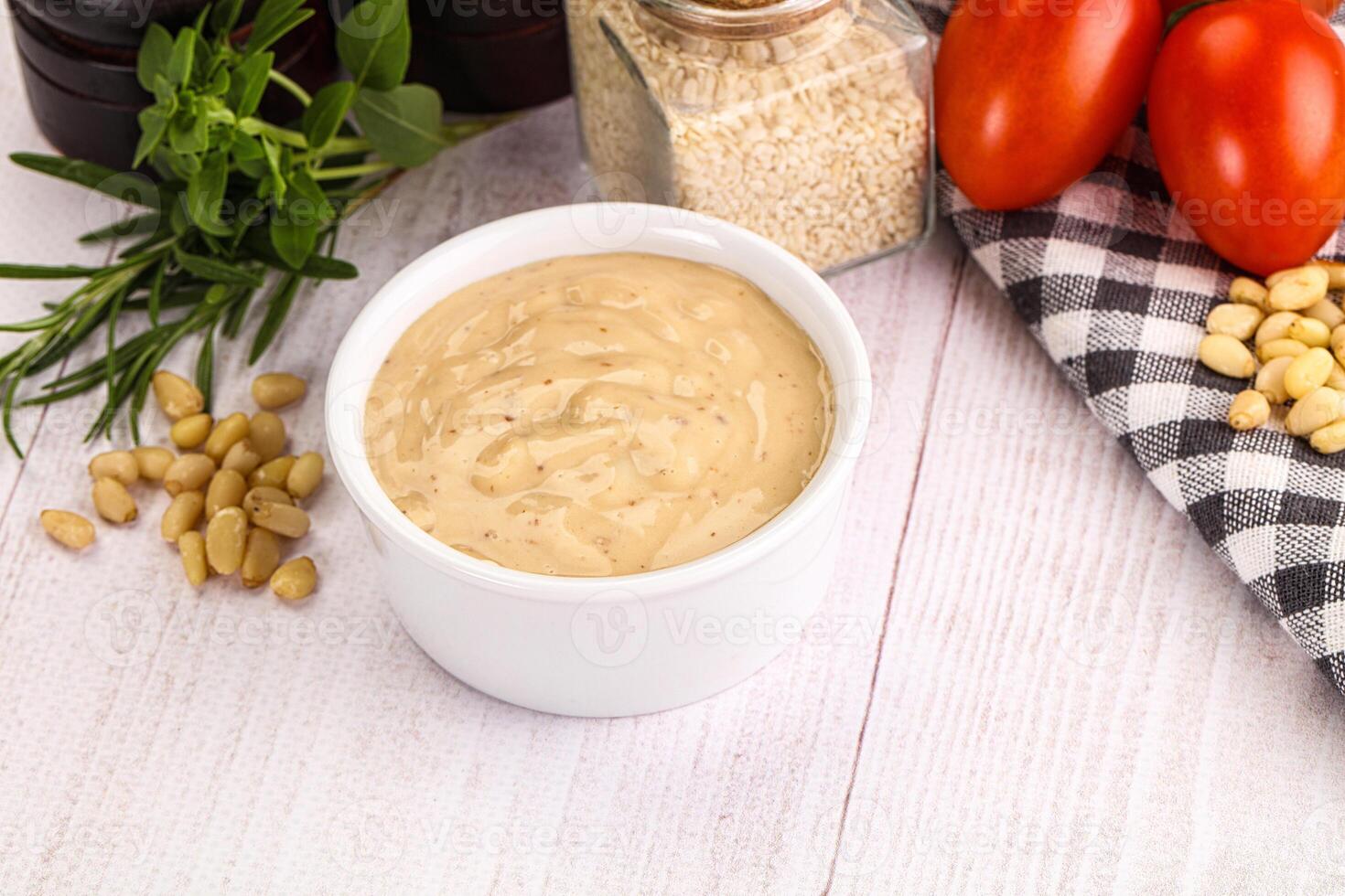 A bowl of mustard with tomatoes, nuts and herbs photo