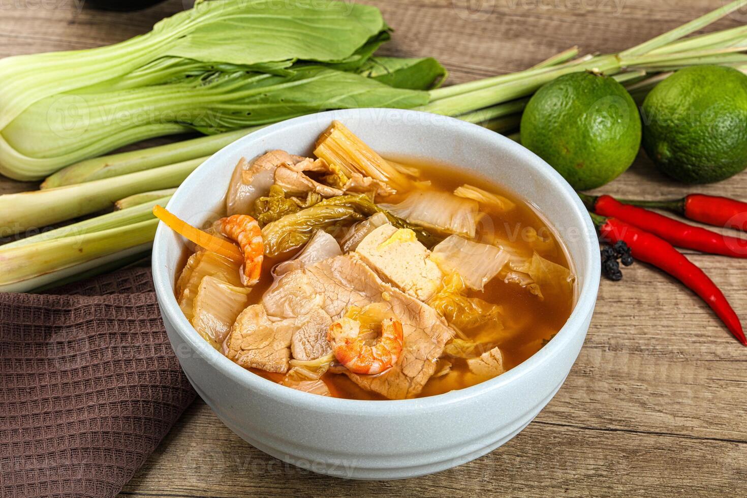 A bowl of soup with a lime and a green pepper photo