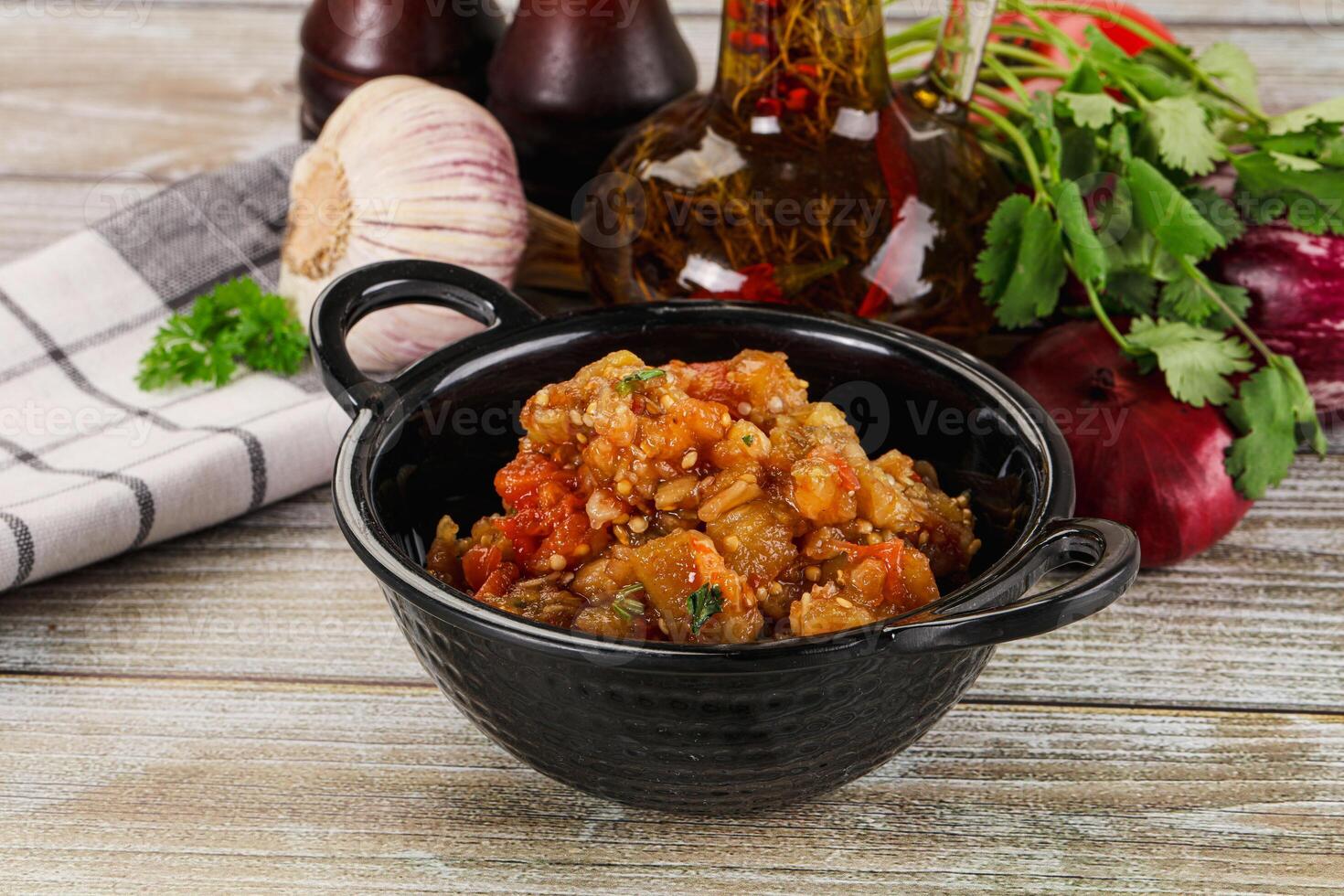 A bowl of food sitting on a table next to some other food photo