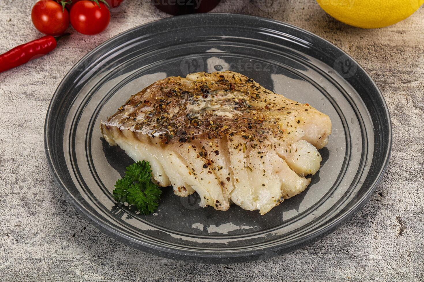 A piece of fish on a plate with some vegetables photo