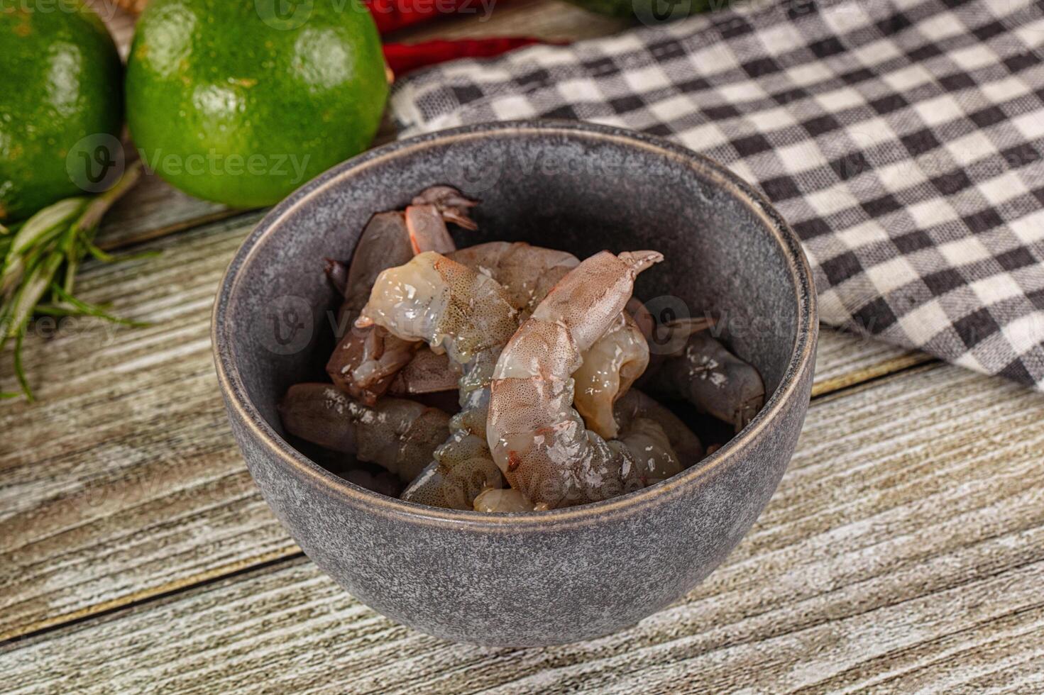 A bowl filled with meat and vegetables on a wooden table photo
