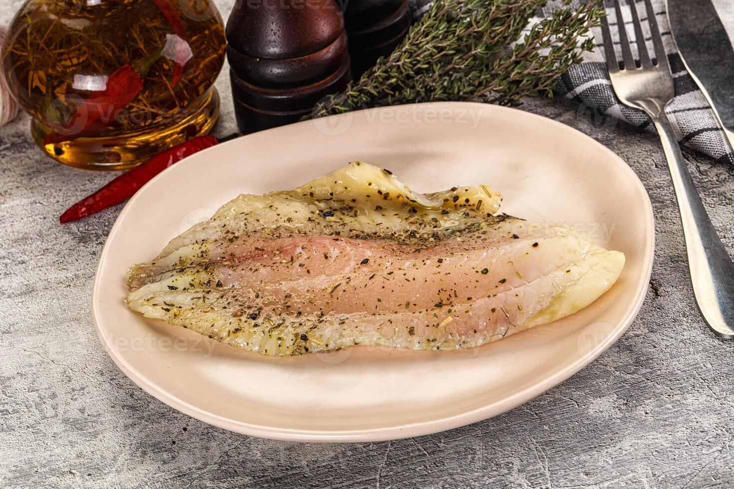 A plate with a fish on it and a bottle of sauce photo