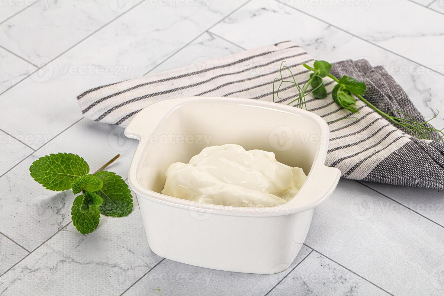 A bowl of yogurt next to a towel and a mint photo