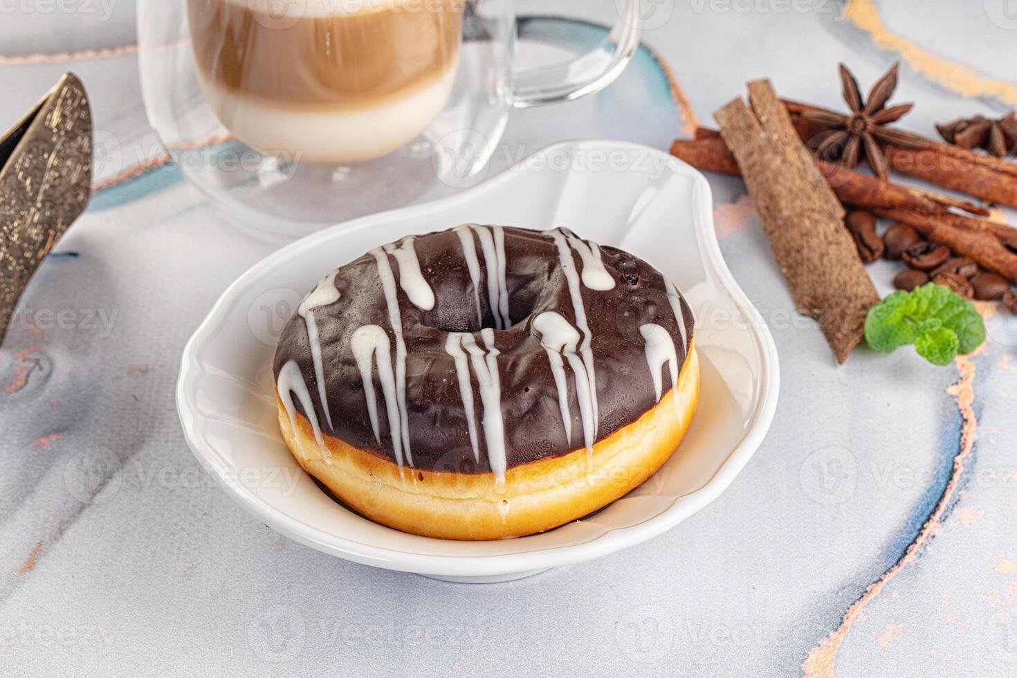 A donut with chocolate icing and cinnamon on a plate photo