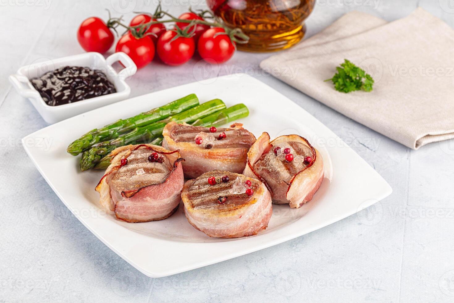 A plate of food with asparagus, tomatoes and bacon photo