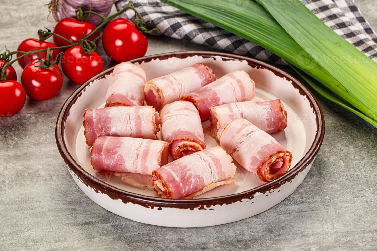 A bowl of bacon wrapped in bacon sitting on a table photo