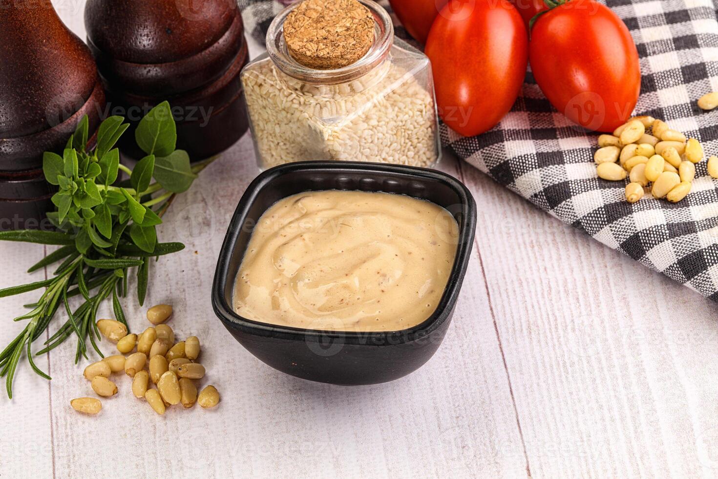 A bowl of mustard with tomatoes, garlic and other ingredients photo
