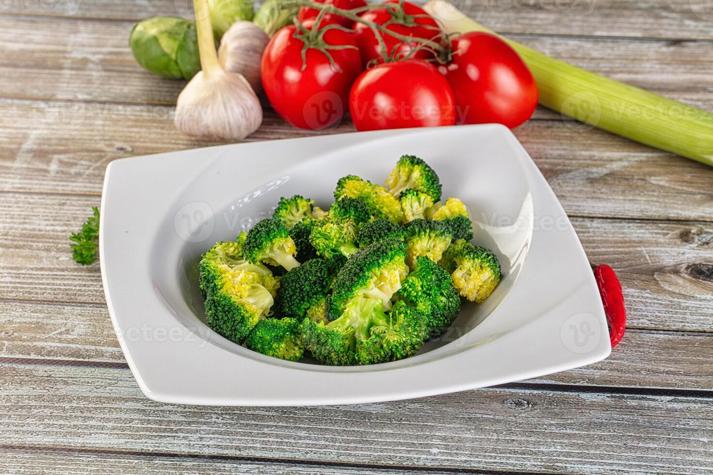 A white plate with broccoli and tomatoes photo