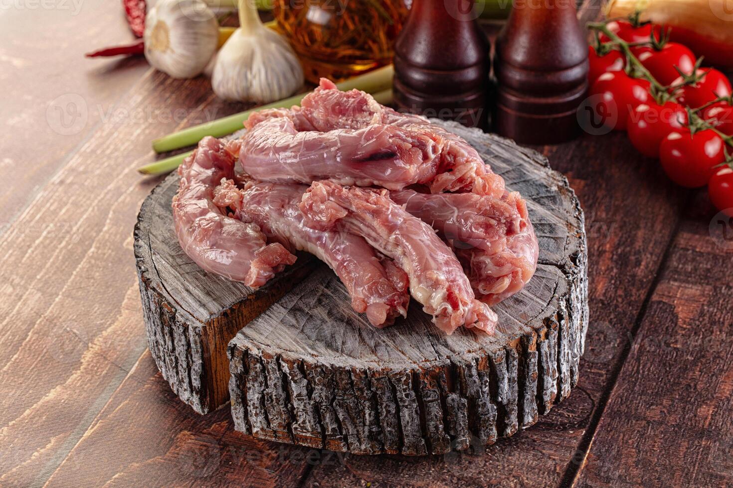 Raw meat on a wooden table with vegetables and spices photo